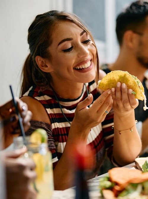 woman-eating-vegan-taco-with-group