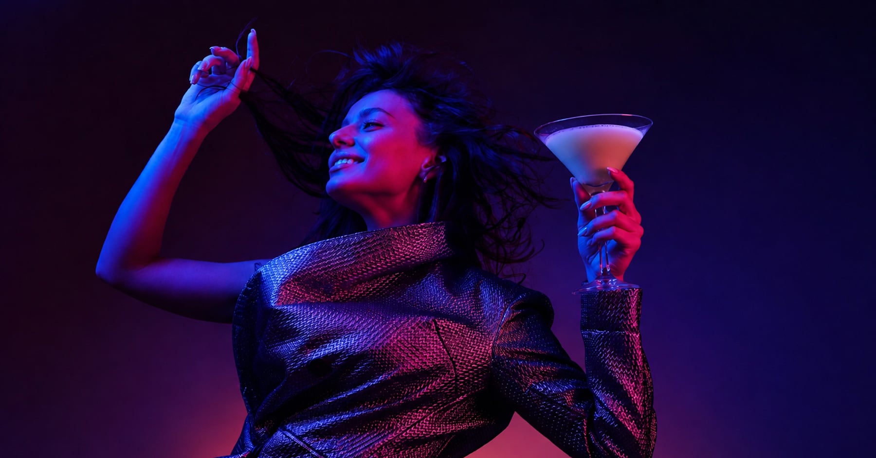 Woman dancing in a club holding a martini glass filled with protein shake